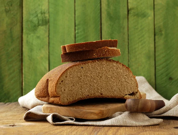 Loaf of rye bread on a wooden table rustic style — Stock Photo, Image