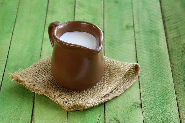 Jarra con leche sobre mesa de madera bodegón rústico —  Fotos de Stock