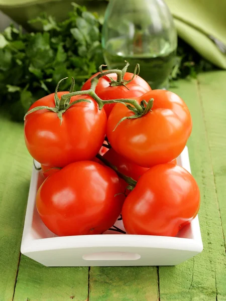 Fresh ripe organic tomatoes on a wooden table — Stock Photo, Image