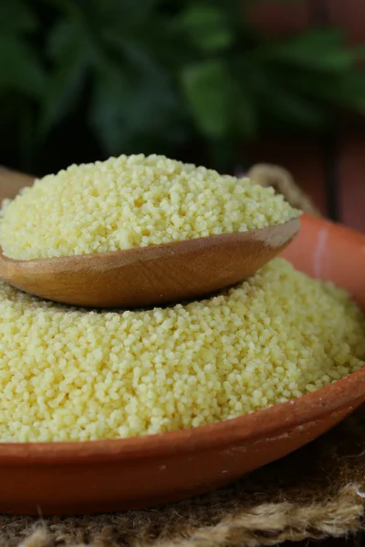 Cous cous cereal in a clay bowl on wooden table — Stock Photo, Image