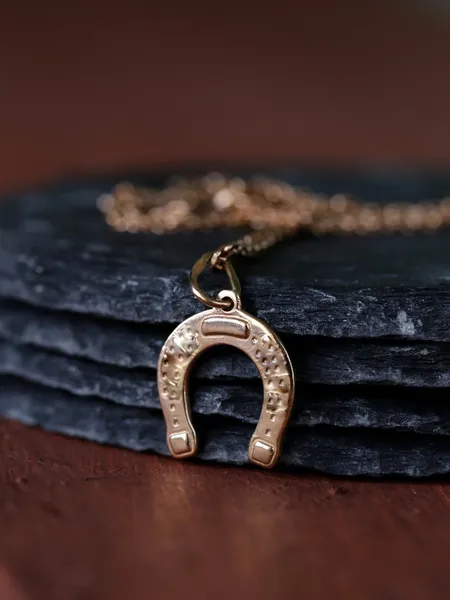 Gold jewelry pendant horseshoe - symbol of luck — Stock Photo, Image