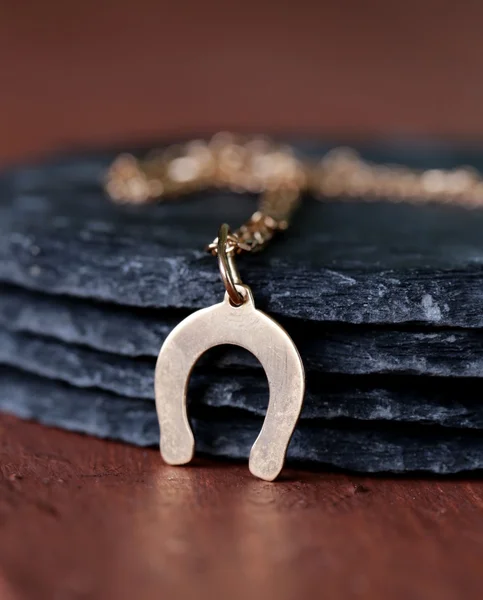 Guld smycken hängsmycke hästsko - symbol för lycka — Stockfoto