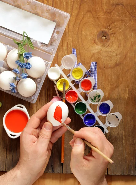 Coloring Easter eggs (hand in the shot) paint and brushes — Stock Photo, Image