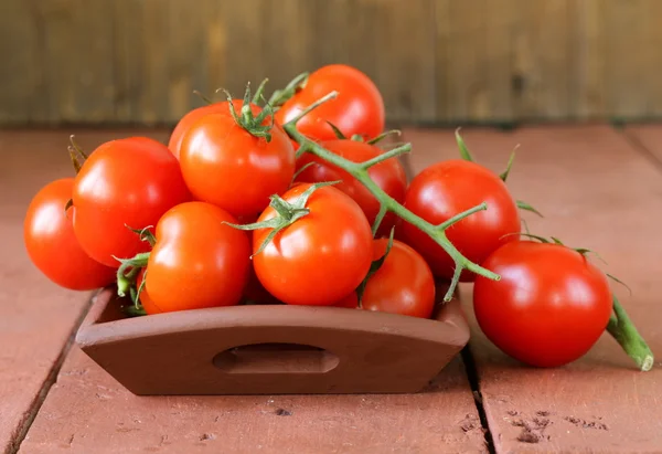 Verse rijpe biologische tomaten op een houten tafel — Stockfoto