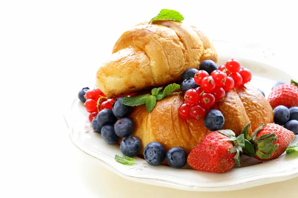 Fresh croissant with berries for breakfast on vintage plate — Stock Photo, Image