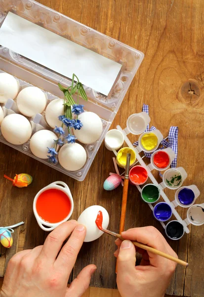 Coloring Easter eggs (hand in the shot) paint and brushes — Stock Photo, Image