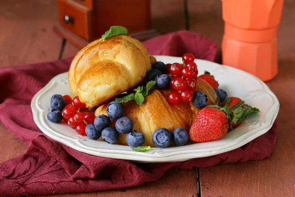 Fresh croissant with berries for breakfast on vintage plate — Stock Photo, Image