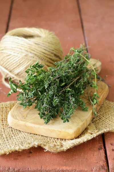 Rosemary verde fresco em uma tábua de corte de madeira — Fotografia de Stock