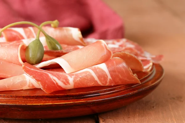 Gesneden gedroogde worstvlees (prosciutto, ham, salami) geserveerd op een houten bord — Stockfoto