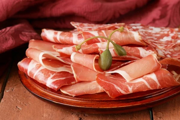 Carne di salsiccia secca affettata (prosciutto, prosciutto, salame) servita su un tagliere di legno — Foto Stock