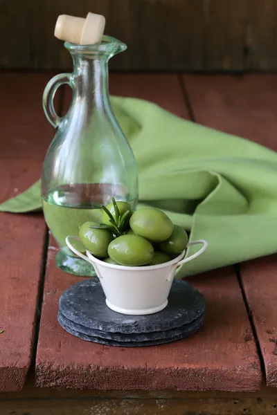 Aceitunas marinado verde en un tazón sobre una mesa de madera — Foto de Stock