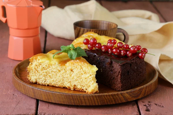 Ассорти торт - шоколад и фрукты на деревянной тарелке — стоковое фото