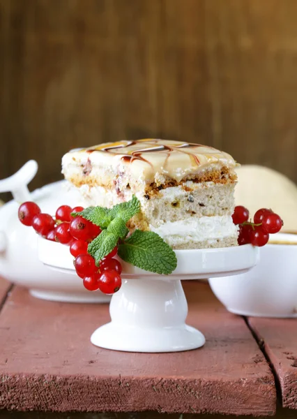 Piece of of vanilla cake decorated caramel sauce and currant — Stock Photo, Image