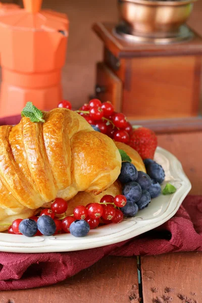 Croissant fresco com bagas para o café da manhã no prato vintage — Fotografia de Stock