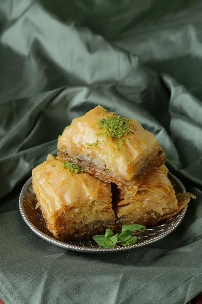 Турецкий арабский десерт паклава с медом и орехами на серебряной тарелке — стоковое фото