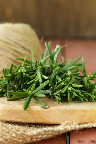 Fresh green rosemary on a wooden chopping board — Stock Photo, Image