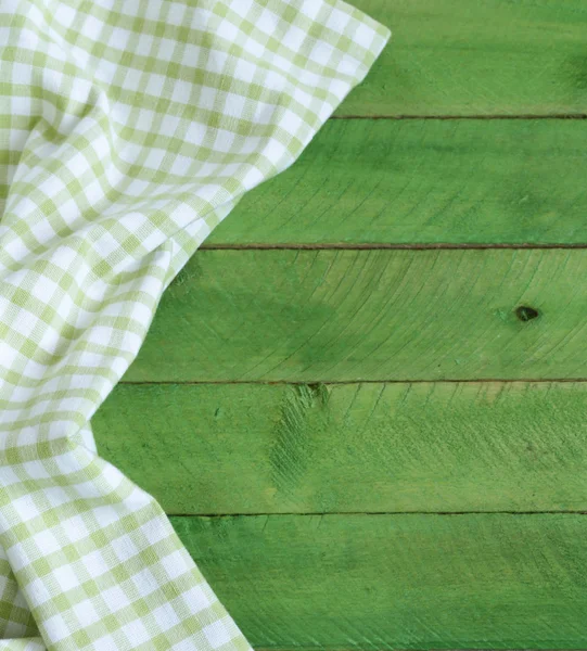 Houten achtergrond met groene geruite keuken handdoek — Stockfoto