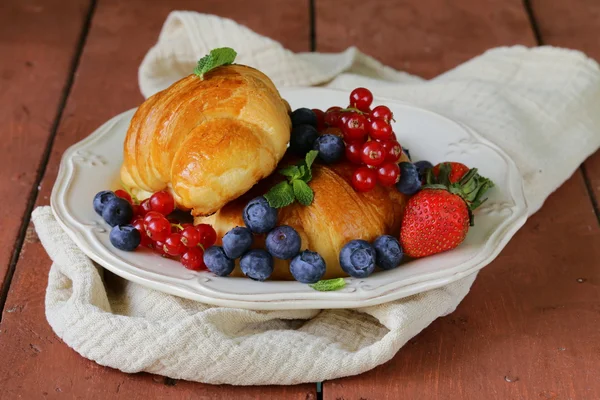 Čerstvý croissant s plody k snídani na vinobraní deska — Stock fotografie