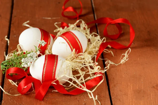 Los huevos de fiesta adornados con la cinta roja - el símbolo de la fiesta de Pascua — Foto de Stock