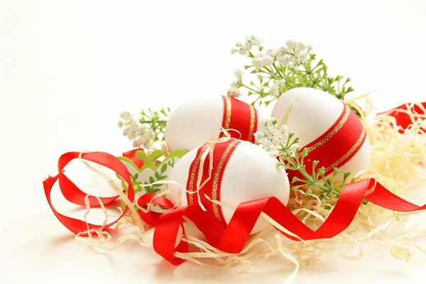 Festive eggs decorated with red ribbon - symbol of Easter holiday — Stock Photo, Image