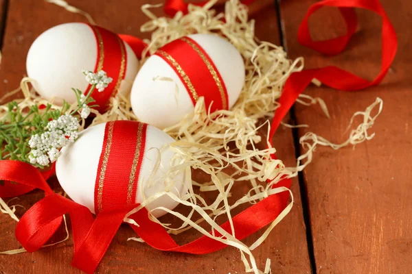 Świąteczne jaja ozdobiony czerwoną wstążką - symbolem Świąt Wielkanocnych — Zdjęcie stockowe