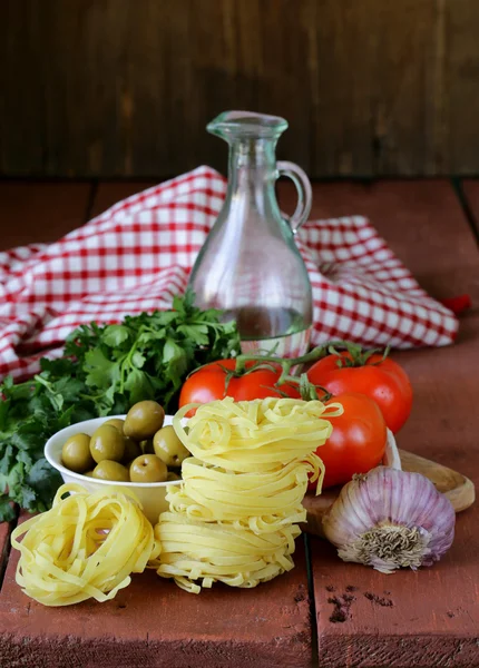 Italian food still life - pasta, olive oil, tomatoes, garlic — Stock Photo, Image