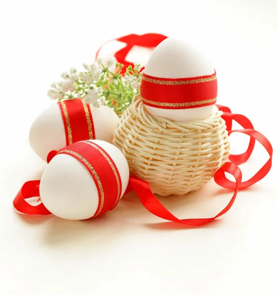 Festive eggs decorated with red ribbon - symbol of Easter holiday — Stock Photo, Image