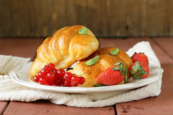 Croissant fresco com bagas para o café da manhã no prato vintage — Fotografia de Stock