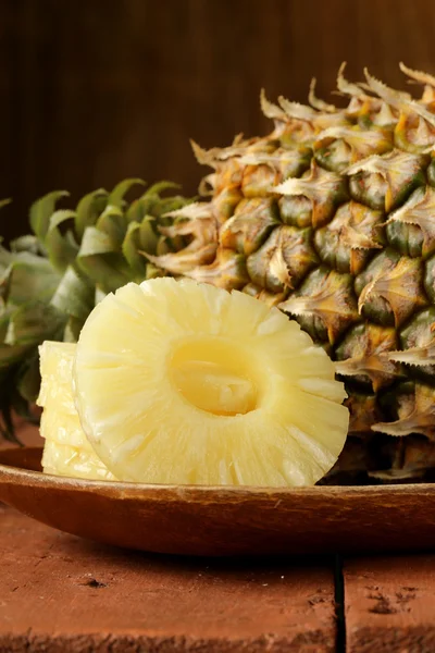 Dessertananas in Scheiben geschnitten auf einem Holzteller — Stockfoto