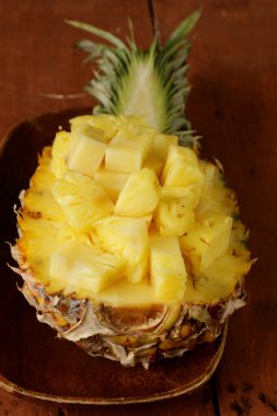 ahşap bir tabağa dilimlenmiş tatlı ananas