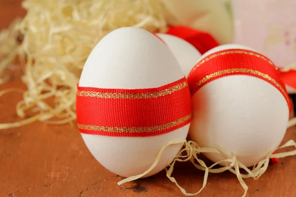 Festive eggs decorated with red ribbon - symbol of Easter holiday — Stock Photo, Image