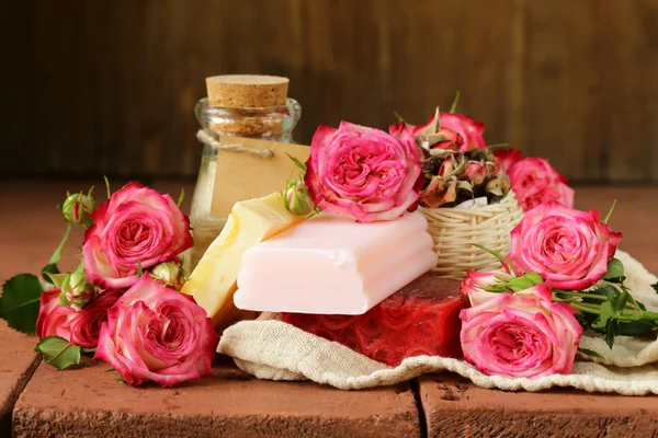 Sapone fatto a mano con il profumo delle rose su un tavolo di legno — Foto Stock