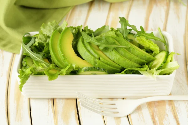 Green salad with avocado and arugula in a white bowl — Stock Photo, Image