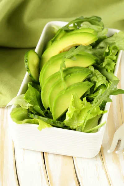 Green salad with avocado and arugula in a white bowl — Stock Photo, Image