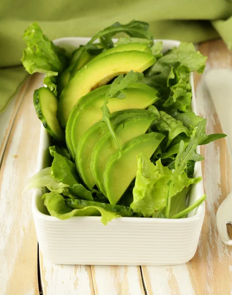 Salada verde com abacate e arugula em uma tigela branca — Fotografia de Stock