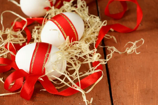 Festive eggs decorated with red ribbon - symbol of Easter holiday — Stock Photo, Image