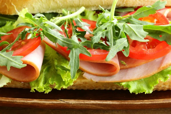 Sanduíche de baguete com rúcula, presunto e tomate — Fotografia de Stock