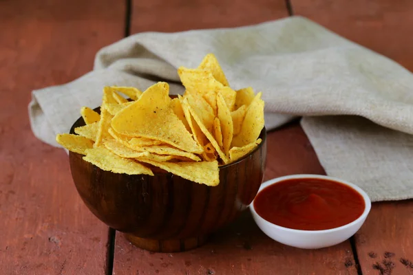 Corn tortilla chips in a bowl with tomato sauce — Stock Photo, Image