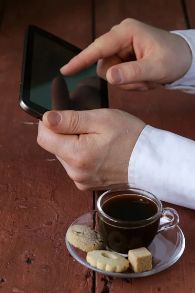 Чашка кофе для бизнесмена с цифровым планшетом на заднем плане — стоковое фото