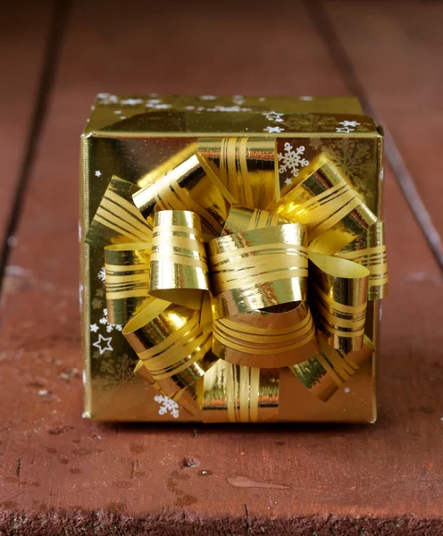 Gold festive gift box with bow on top — Zdjęcie stockowe