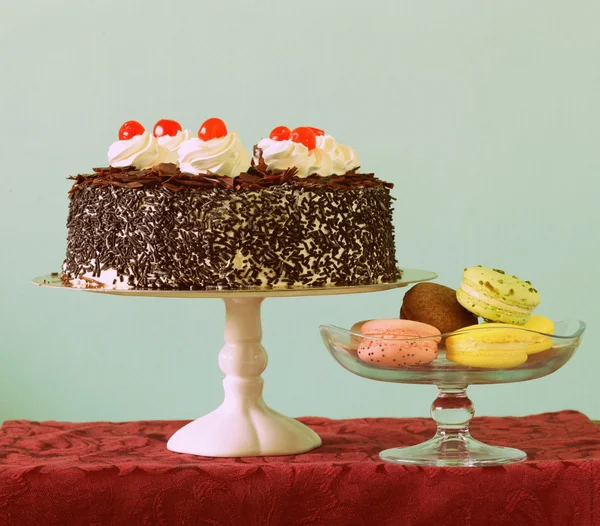 Chocolate cake and almond macaroon cookies on the dessert table,toned photo — Stock Photo, Image