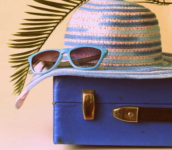Старомодный синий чемодан для путешествий и пляжная шляпа — стоковое фото
