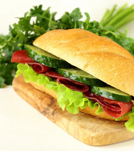 Füstölt hús, uborka, saláta, friss szendvicset — Stock Fotó