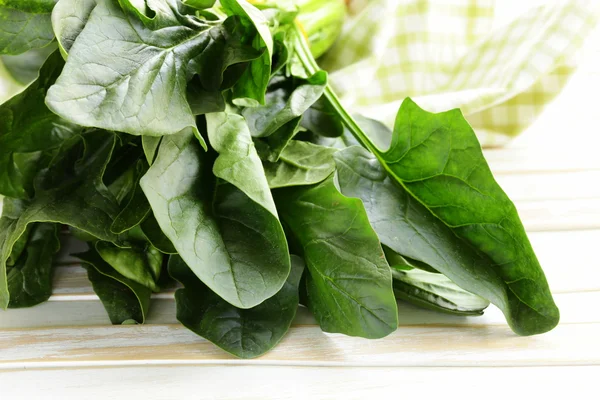 Fresh green spinach leaves on a wooden table — Stock Photo, Image