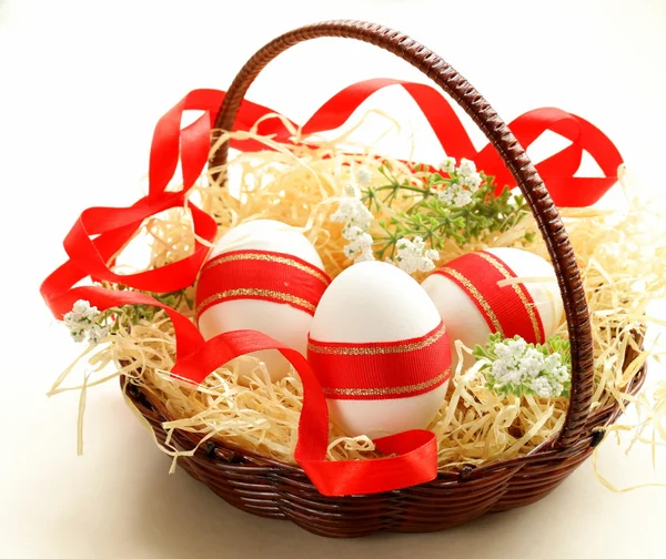 Festive eggs decorated with red ribbon - symbol of Easter holiday — Stock Photo, Image