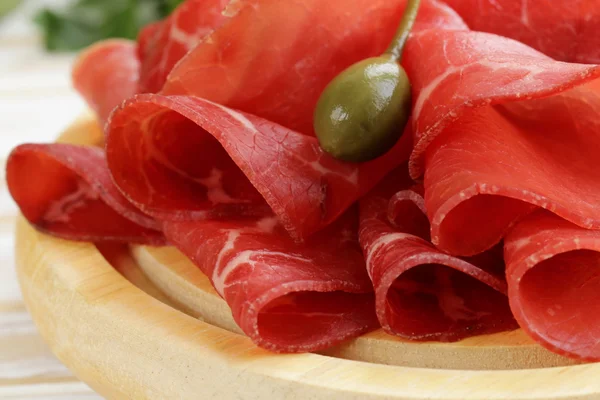 Collation au bresaola de viande fumée sur une planche à découper — Photo