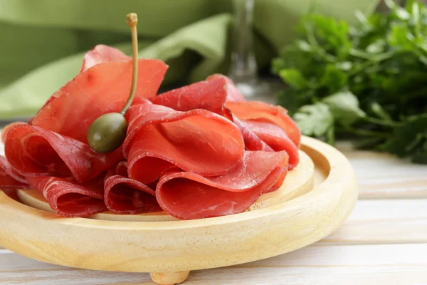 Lanche de bresaola de carne defumada em uma placa de corte — Fotografia de Stock