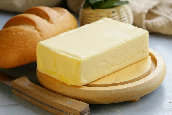 Piece of fresh butter for breakfast on a wooden board — Stock Photo, Image