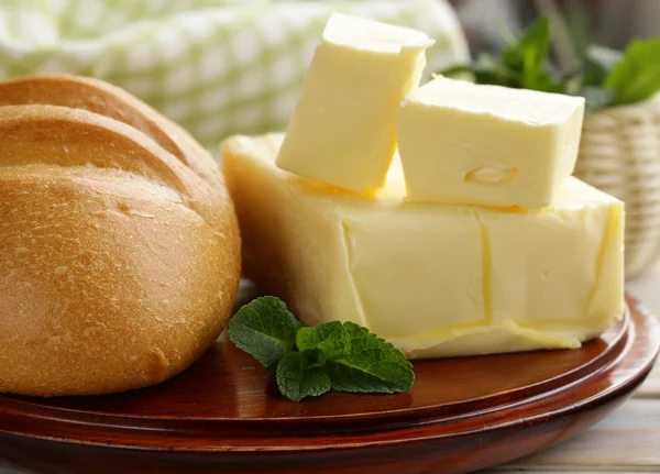 Pedazo de mantequilla fresca para el desayuno en una tabla de madera —  Fotos de Stock