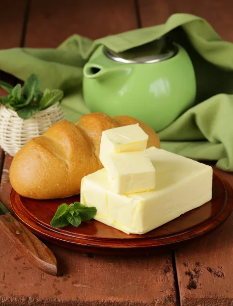 Pièce de beurre frais pour le petit déjeuner sur une planche de bois — Photo